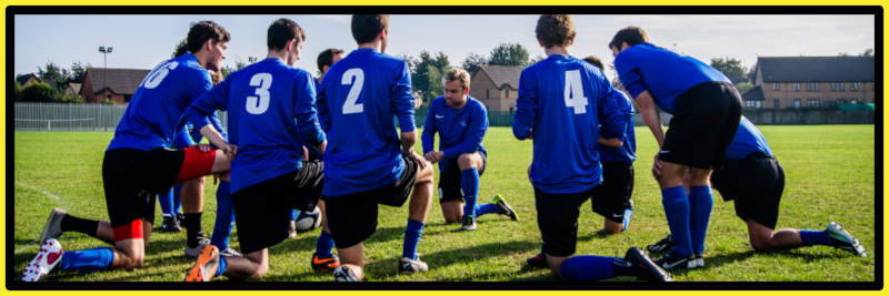Group of young footballers kneeling on pitch- Do you need sports club insurance?